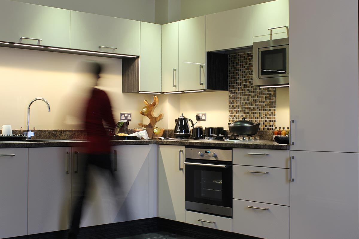 A business guest preparing dinner in one of our self catering, open plan apartments near the corporate hubs of Exeter